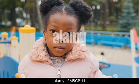 Close up serious child face portrait cute little African American kid sad upset close-up alone small girl baby daughter looking at camera calm ethnic Stock Photo