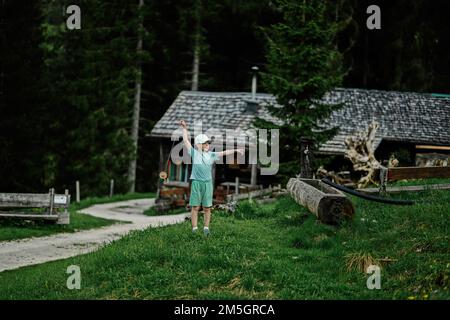 Boy stand against wooden house at Vorderer Gosausee, Gosau, Upper Austria. Stock Photo