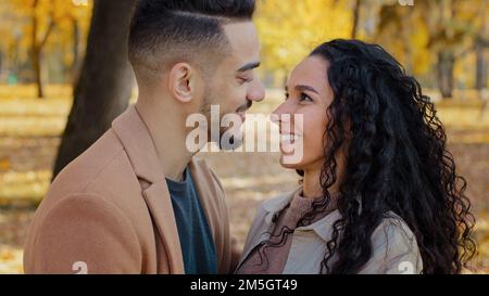 Multiracial ethnic Hispanic happy married couple in love standing outdoors man and woman boyfriend and girlfriend wife and husband looking at each Stock Photo