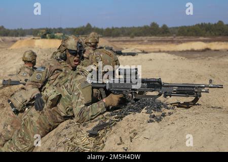 An Assistant Gunner shouts commands to his M240 Gunner while engaging targets during a combined arms live fire exercise involving Paratroopers assigned to the 1st Battalion, 505th Parachute Infantry Regiment, 3rd Brigade Combat Team, 82nd Airborne Division and Polish Soldiers with the 19th Mechanized Brigade. The 3rd Brigade Combat Team, 82nd Airborne Division is deployed in Poland to assure our Allies and strengthen the NATO Alliance. Stock Photo