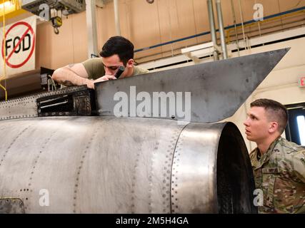 U.S. Air Force Staff Sgt. Spiridon Tsamis, left, and Senior Airman Tyler Rickle, aerospace propulsion mechanics with the 461st Maintenance Group, conduct an inspection and perform maintenance on an E-8C Joint STARS aircraft engine at Robins Air Force Base, Georgia, March 17, 2022. Aerospace propulsion mechanics inspect, maintain, modify, test, and repair propellers, turboprop and turboshaft engines, jet engines, small gas turbine engines, and engine ground support equipment. Stock Photo