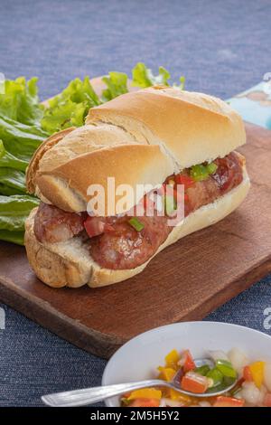 Choripan, typical argentine sandwich with chorizo and creole sauce. Stock Photo