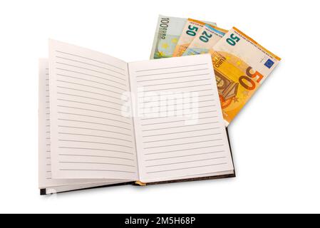 Open notebook with lined paper with euro banknotes between the pages, isolated on white with clipping path, budget, balance sheet concept Stock Photo