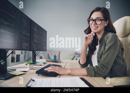 Profile side photo of smiling charming lady hand on keyboard typing java script keys create interface modern app indoor room workstation Stock Photo