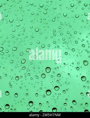 window with rain drops on green background. window raindrops. Stock Photo