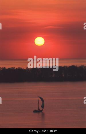 Great Lakes Seaway Trail - Sunset at Presque Isle State Park. A sailboat floats on tranquil waters under a brilliant sunset in Presque Isle State Park. Presque Isle State Park, Pennsylvania (42.171° N 80.104° W) Stock Photo