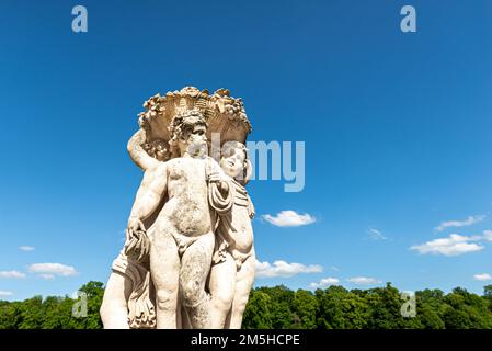 Maincy, France - May 21, 2022: A sculpture representing three cherubim in a french classical garden (Vaux-le-Vicomte). Photo taken in an early summer Stock Photo