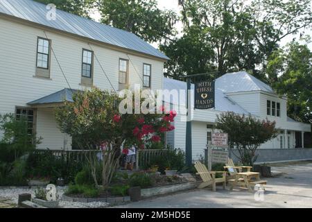 Edisto Island National Scenic Byway - Bailey's Store. The white paneling of Bailey's Store stands behind brilliant red flowers. Location: South Carolina (32.560° N 80.280° W) Stock Photo