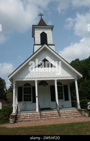 Edisto Island National Scenic Byway - Trinity Episcopal Church. The youngest and the smallest of the three Edisto churches on the National Register of Historic Places, the Trinity Episcopal Church bathes in sunlight with a backdrop of blue sky and cotton-like clouds. Location: South Carolina (32.570° N 80.283° W) Stock Photo