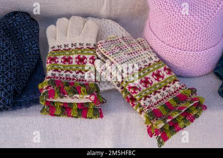 Women's knitted wool winter gloves with pattern. Gloves knitted with jacquard. Christmas and winter concept. Selective focus. Stock Photo