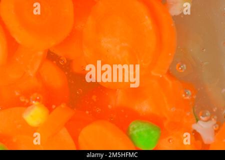 Close-up view of the vegetables with carrots, peas, cauliflower and corn in water background. Texture of boiling soup vetetables drink with macro Stock Photo