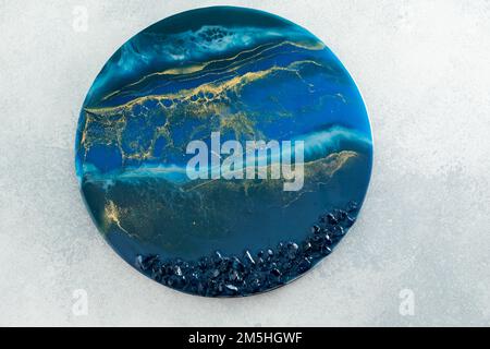 Resin art with dark blue colors and stones on gray background. Epoxy decoration Stock Photo