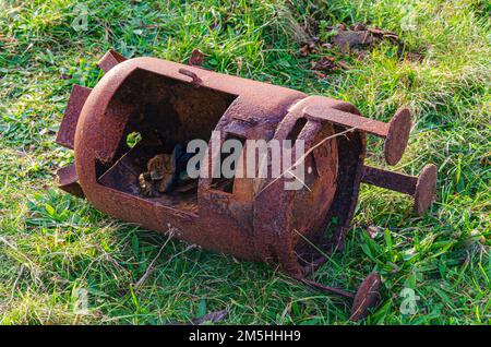 Old rusted wood burner discarded on the grass verge at Tyrella beach County Down Northern Ireland Stock Photo