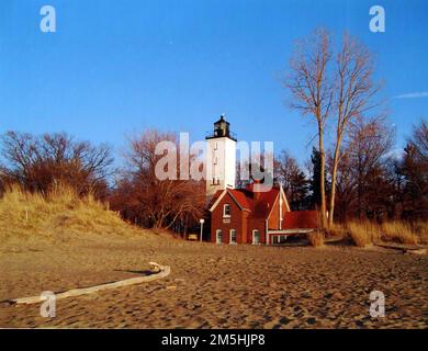 Great Lakes Seaway Trail - Presque Isle Lighthouse. The red brick of the Presque Isle Lighthouse stands out in this autumn beach photo. Pennsylvania (42.153° N 80.078° W) Stock Photo