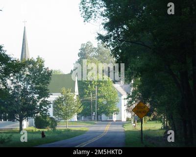 Harriet Tubman Underground Railroad Byway - On the Road to East New Market Historic District. A tree-lined country road on a hazy summer day leads into the Town of East New Market's National Historic District. East New Market, Maryland Stock Photo