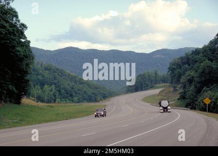 Country Music Highway - Highway 23 near Pikeville Looking South. Two vehicles pass each other near a curve through tree-covered, rounded mountains on Highway 23, the Country Music Highway, near Pikeville, Kentucky. Location: Near Pikeville, Kentucky Stock Photo