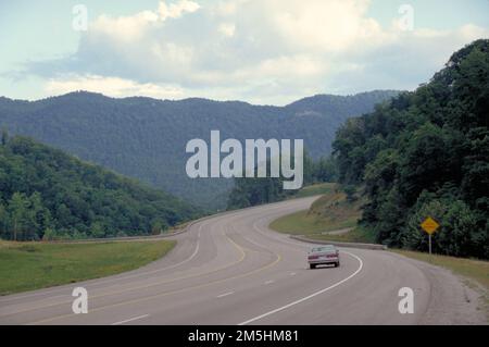 Country Music Highway - Highway 23 near Pikeville Looking South. A lone driver approaches a curve through tree-covered, rounded mountains on Highway 23, the Country Music Highway, near Pikeville, Kentucky. Location: Near Pikeville, Kentucky Stock Photo