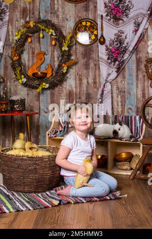 happy little girl is played with cute fluffy easter ducklings Stock Photo