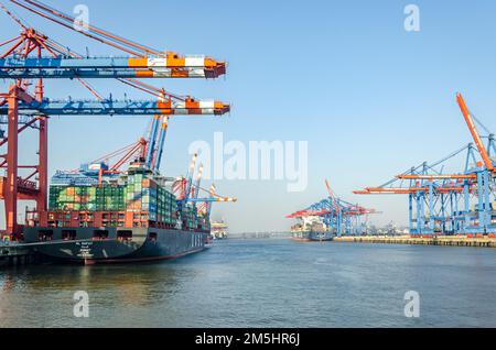 Wide shot of container vessel and harbour facilities at a the Waltershof Eurogate and Burchardkai container terminal in the port area of Hamburg, Germ Stock Photo