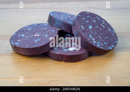 Thick slices of pork farmhouse black pudding isolated on a wooden background Stock Photo