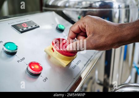 Close-up of engineer operating equipment with panel for processing chemical material in factory Stock Photo
