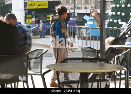 Beirut, Lebanon. 27th Dec, 2022. A Syrian boy begs barefoot in a coffee shop in Beirut, Lebanon, December 27 2022. Despite UNHCR, the UN refugee Agency, and many other NGOs provide Syrian refugees with help in Lebanon, many children are exploited by traffick. (Photo by Elisa Gestri/SIPA USA) Credit: Sipa USA/Alamy Live News Stock Photo