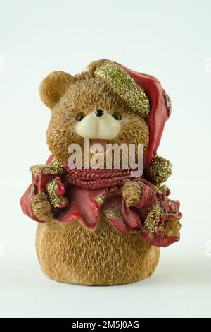 Cute bear figurine with gifts and Santa hat on white background Stock Photo