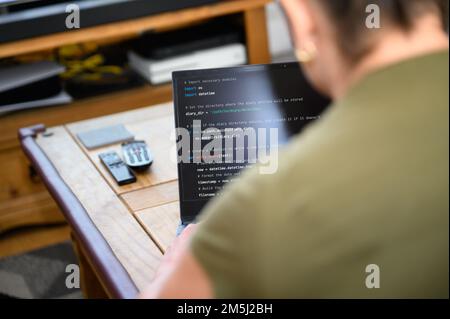 Coding in the house, a woman writing code on a laptop for an app or website while working from home Stock Photo