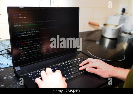 Coding in the house, a woman writing code on a laptop for an app or website while working from home Stock Photo