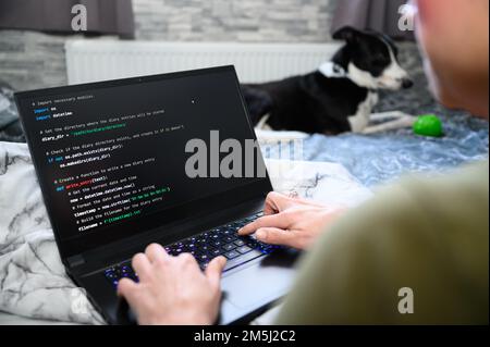 Coding in the house, a woman writing code on a laptop for an app or website while working from home Stock Photo