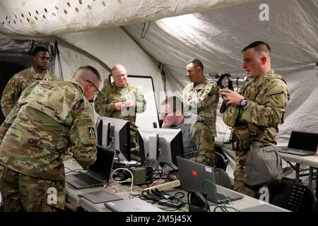 Spc. Mark Crossen, an information technology specialist assigned to 38th Infantry Division, prepares a command workstation for a remote briefing during a command post exercise at Fort Campbell, Ky., Mar. 18, 2022. The exercise provided the division the opportunity to train their leadership and staff utilizing mission command systems within a large scale ground combat operations simulation. Stock Photo