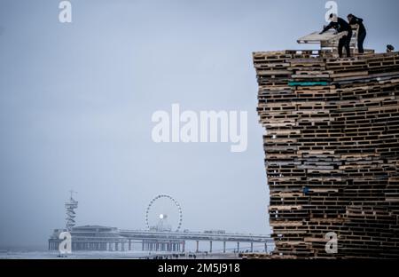 SCHEVENINGEN - The construction of the depot for the New Year's bonfire on the Noorderstrand in Scheveningen. The woodpile, which cannot exceed 10 by 10 by 10 meters this year, is traditionally set on fire at the turn of the year. ANP BART MAAT netherlands out - belgium out Stock Photo