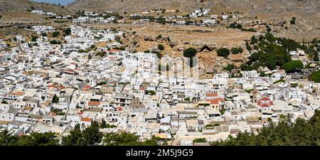 Lindos, Rhodes, Greece - May 2022: Panoramic aerial view of whitewashed buildings in the town Stock Photo