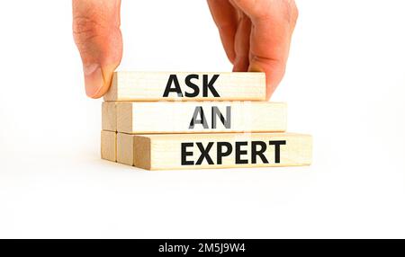 Ask an expert symbol. Concept words Ask an expert on wooden blocks on a beautiful white table white background. Businessman hand. Business and ask an Stock Photo