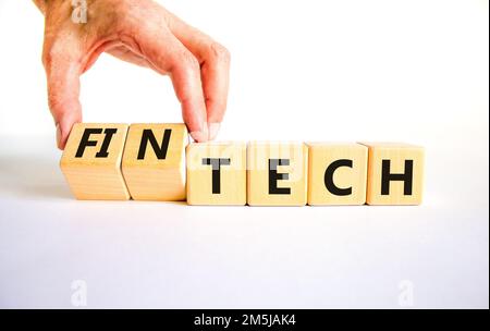 Tech or fintech symbol. Concept word Tech and Fintech on wooden cubes. Businessman hand. Beautiful white table white background. Business and tech or Stock Photo
