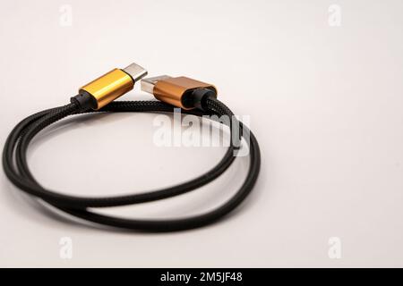 detailed close up of a black braided USB cable with golden colour connectors Stock Photo