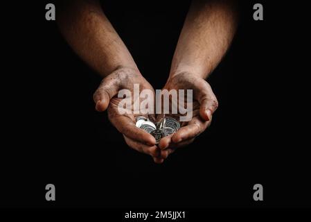 poverty in Ukraine. Dirty hands of a poor homeless man holding Ukrainian hryvnias in coins Stock Photo