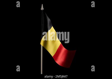 Small national flag of the Belgium on a black background. Stock Photo