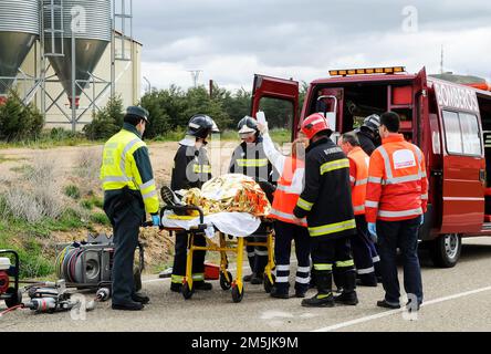 Victim of a traffic accident is attended by public emergency services with firefighters, paramedics and police. Stock Photo