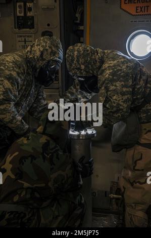 U.S. Soldiers assigned to the 110th Chemical Battalion mitigate a simluated leak in a multiple round container during Chemical, Biological, Radiological, Nuclear, and Explosives training aboard a C-17 Globemaster III aircraft during exercise Operation Iron Flight, March 20, 2022, Joint Base Lewis-McChord, Washington. The pre-planned exercise in conjunction with Exercise Rainier Kraken evaluated joint forces’ ability to employ the force and perform in a high-intensity, contested environment. Stock Photo