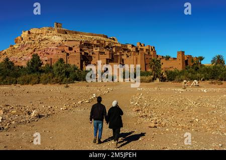 Morocco. Ksar d'Ait Ben Haddou in the Atlas Mountains of Morocco. UNESCO World Heritage Site since 1987. A couple of tourist walking at the village Stock Photo