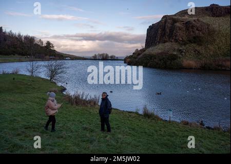 Thursday December 29th 2022: Edinburgh Scotland, UK. Tourists take photos in Holyrood Park beside Dunsapie Loch. Stock Photo