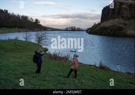 Thursday December 29th 2022: Edinburgh Scotland, UK. Tourists take photos in Holyrood Park beside Dunsapie Loch. Stock Photo