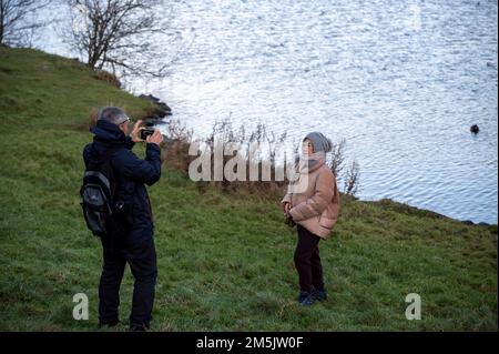 Thursday December 29th 2022: Edinburgh Scotland, UK. Tourists take photos in Holyrood Park beside Dunsapie Loch. Stock Photo