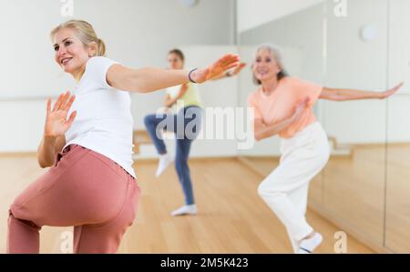 Woman performing aerobic dance during group training Stock Photo