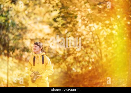 Fun Enjoy Outdoor Autumn Nature. Tourist Woman Walking And Taking Photos In Forest. Lady Photographed Nature. Young Pretty Caucasian Happy Smiling Stock Photo