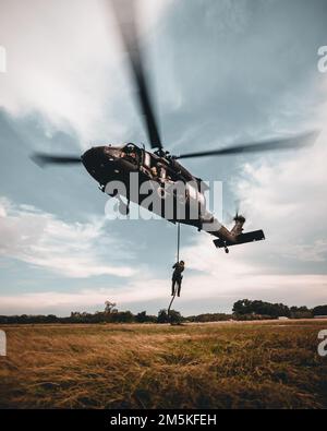 A Royal Thai Army Special Forces Soldier, slides down a fast-rope-insertion and extraction system while in a hovering UH-60 Blackhawk helicopter during Hanuman Guardian 2022 in Lopburi, Kingdom of Thailand, March 22, 2022. HG 22 provides a venue for both the United States and the RTA to advance interoperability and increase partner capacity in planning and executing complex and realistic multinational force and combined task force operations. Stock Photo