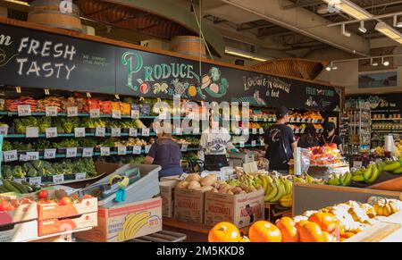 People shopping in the supermarket. Buyer Shopping Groceries In Supermarket. Woman employee restocking the shelves in grocery store. Shopping, sale, c Stock Photo
