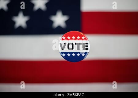 Vote button with an American flag in the background. Stock Photo