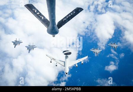 A U.S. Air Force E-3 Sentry, assigned to Tinker Air Force Base, Oklahoma City, OK, leads a formation of F-15 Eagles from the Florida Air National Guard's 125th Fighter Wing over the coast of North Carolina during an air refueling mission, March 23, 2022. Stock Photo